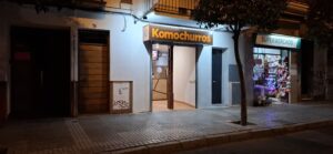 Foto del local Komochurros de noche iluminando la fachada